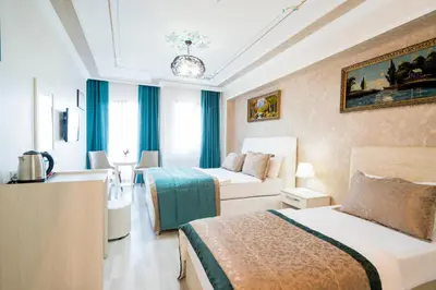 a hotel room with two beds and a couch at ATAM HOTEL in Istanbul