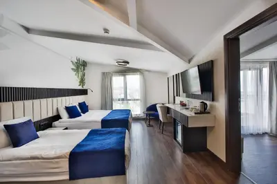 a hotel room with two beds and a desk at Kavala Hotel in Bursa
