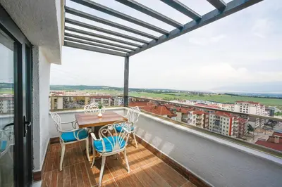 a balcony with a wooden table and chairs at Kavala Hotel in Bursa