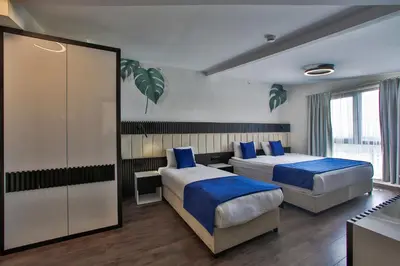 a hotel room with two beds with blue pillows at Kavala Hotel in Bursa