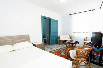 a bedroom with a bed and a tv and chairs at Blue Suites by V in Istanbul