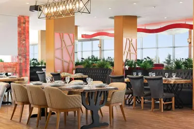 a dining room with tables and chairs and windows at Wyndham Cerkezkoy in Cerkezkoy