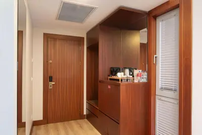 a room with a kitchen with wooden cabinets and a door at Ramada Plaza by Wyndham Istanbul Atakoy in Istanbul