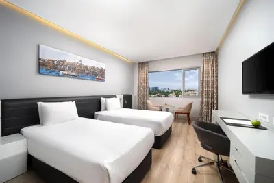 a hotel room with two beds and a desk at Ramada Plaza by Wyndham Istanbul Atakoy in Istanbul
