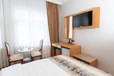 a hotel room with a bed and a desk and a tv at Seatanbul Hotel in Istanbul