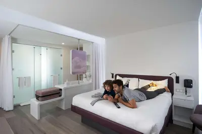 a man and a boy laying on a bed at YOTELAIR Istanbul Airport, Duty free - International Transit area in Istanbul