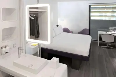 a room with a bed and a sink and a mirror at YOTELAIR Istanbul Airport, Duty free - International Transit area in Istanbul