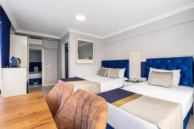 a hotel room with two beds and a table at Sirkeci Grand Family Hotel & SPA in Istanbul