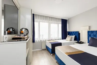 a hotel room with two beds and a kitchen at Sirkeci Grand Family Hotel & SPA in Istanbul