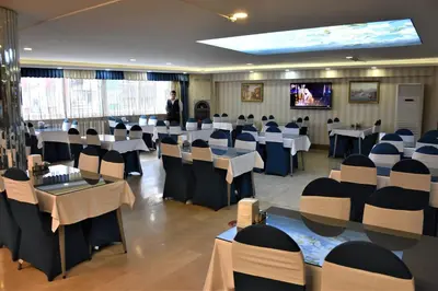 a room with tables and chairs and a man standing in a room at DİNAR HOTEL in Istanbul