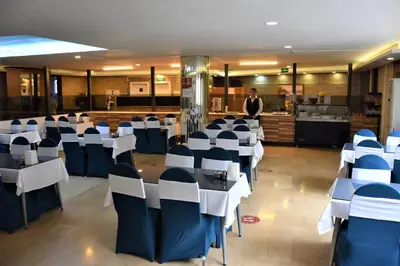 a room with tables and chairs with a man in the background at DİNAR HOTEL in Istanbul