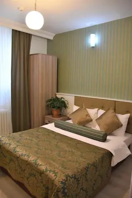 a bedroom with a bed with a green wall at DİNAR HOTEL in Istanbul