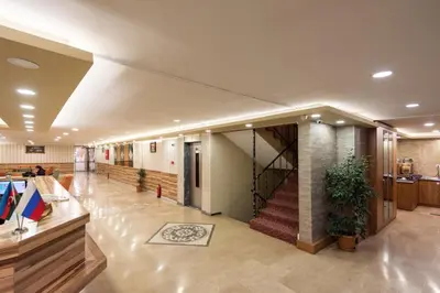 a large lobby with a staircase in a building at DİNAR HOTEL in Istanbul