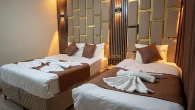 two beds in a hotel room with towels on them at La Fortuna Taksim Hotel in Istanbul