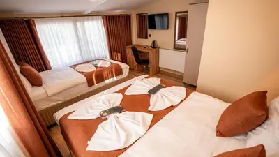 a hotel room with two beds with towels on them at La Fortuna Taksim Hotel in Istanbul