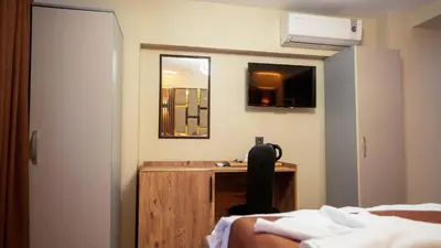 a bedroom with a bed and a desk and a mirror at La Fortuna Taksim Hotel in Istanbul