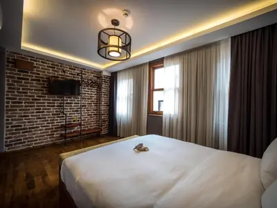 a bedroom with a large white bed and a brick wall at Blu Hotel in Istanbul