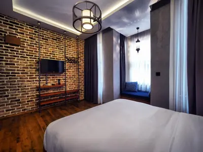 a bedroom with a white bed and a brick wall at Blu Hotel in Istanbul