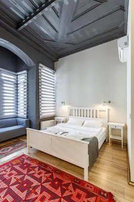 a bedroom with a white bed and a red rug at Hotel Miro Mansion Old City in Istanbul
