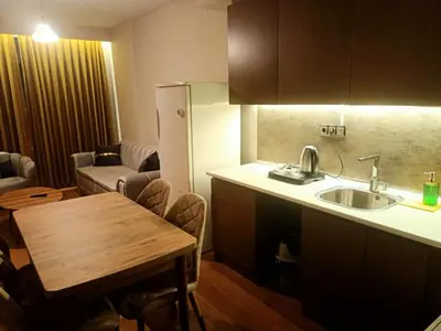 a kitchen with a sink and a table and a refrigerator at FALCON PalaS OTEL in Istanbul