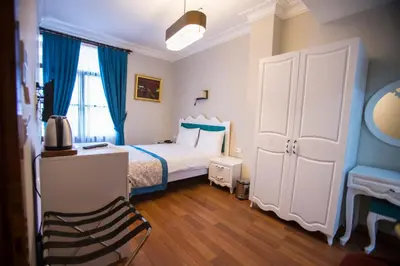 a bedroom with a bed with blue curtains and a desk at The Void Hotel in Istanbul