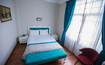 a bedroom with a blue bed and a red chair at The Void Hotel in Istanbul