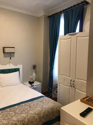 a bedroom with a bed and a cabinet and a window at The Void Hotel in Istanbul