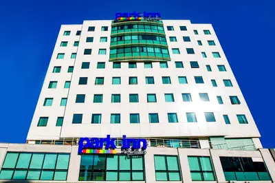 a tall white building with a blue sign on it at Park Inn by Radisson Istanbul Asia Kavacik in Istanbul