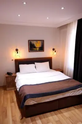 a bedroom with a large white bed with two lamps at Sheriff Residence in Istanbul