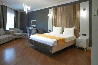a bedroom with a large bed and a living room at Vital Thermal Hotel & SPA in Termal