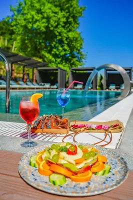 a plate of food on a table next to a pool at Vital Thermal Hotel & SPA in Termal