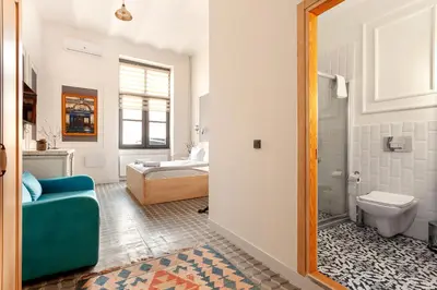 a bathroom with a blue couch and a toilet at Cezayir Rooms in Istanbul