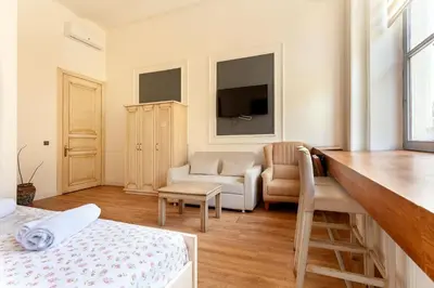 a room with a bed and a couch and a tv at Cezayir Rooms in Istanbul