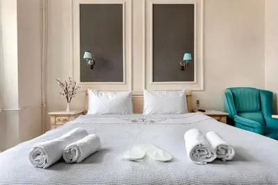 a bedroom with a bed with towels and a blue chair at Cezayir Rooms in Istanbul