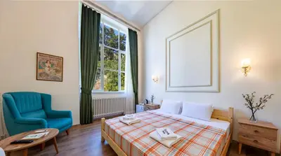 a hotel room with a bed and a blue chair at Cezayir Rooms in Istanbul