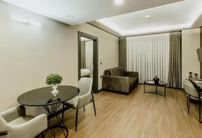 a living room with a table and a couch at Kızılkaya Business Otel in Korfez