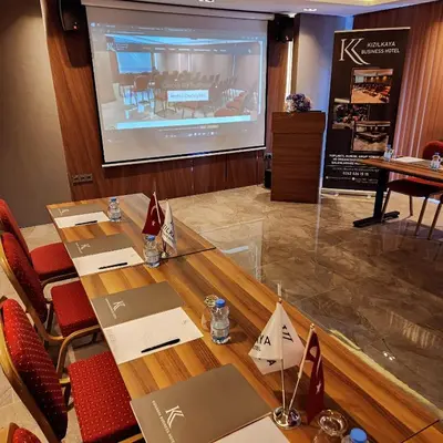 a conference room with a projection screen and a table at Kızılkaya Business Otel in Korfez