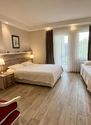 a large bedroom with two beds and a large window at Yankı Hotel in Çekirge