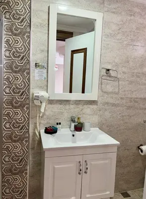 a bathroom with a white sink and a mirror at Yankı Hotel in Çekirge
