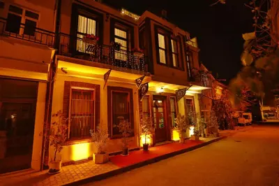 a building with lights on a street at night at Mimoza Butik Otel Buyukada in Buyukada
