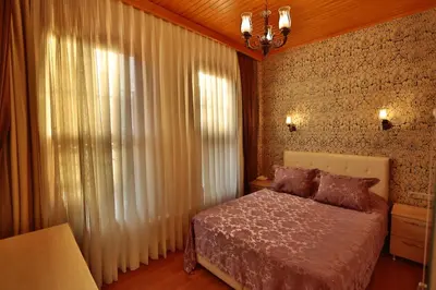 a bedroom with a bed and a window with curtains at Mimoza Butik Otel Buyukada in Buyukada