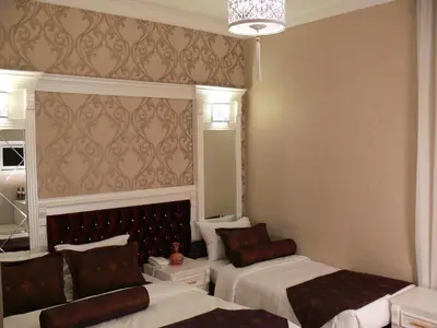 a bedroom with two beds and a chandelier at Hotel Coliseum in Istanbul