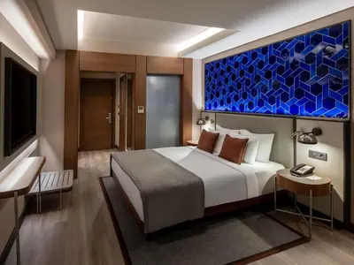 a bedroom with a bed and a large painting on the wall at Mercure Istanbul Altunizade in Istanbul