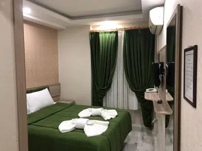 a hotel room with a green bed with towels on it at Kaya Madrid Hotel in Istanbul