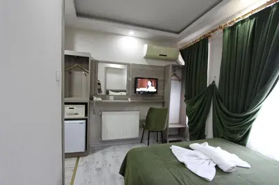 a hotel room with a green bed and a bathroom at Kaya Madrid Hotel in Istanbul