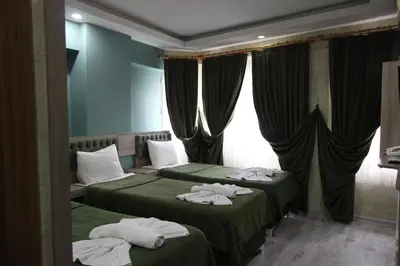 two beds in a hotel room with towels on them at Kaya Madrid Hotel in Istanbul