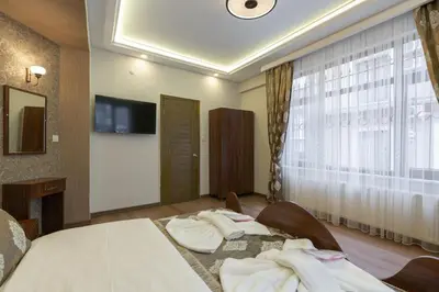a hotel room with a bed and a tv on the wall at Capricorn by Otantik Suites in Istanbul