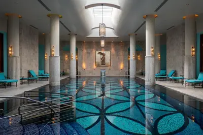 a pool in a hotel lobby with blue chairs at Four Seasons Hotel Istanbul at the Bosphorus in Istanbul