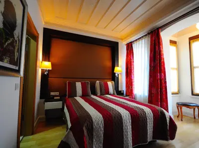a bedroom with a bed with a red and white blanket at Ottopera Hotel in Istanbul