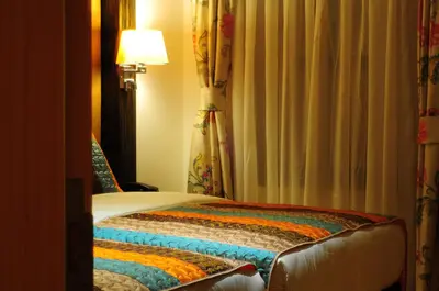 a hotel room with a bed and a lamp and curtains at Ottopera Hotel in Istanbul